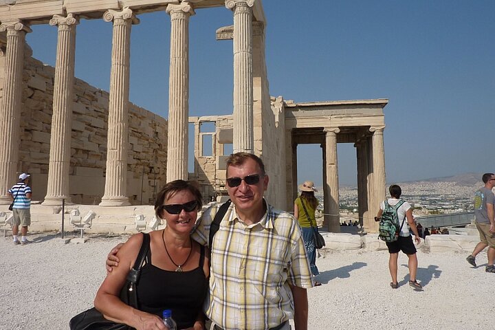 Mężczyzna obejmuje kobietę ubrani są casualowo w tle kolumny starożytne