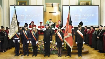 grupa osób ubranych w odświętne stroje śpiewa hymn