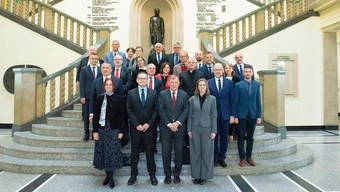 grupa ludzi stoi na schodach wewnątrz budynku